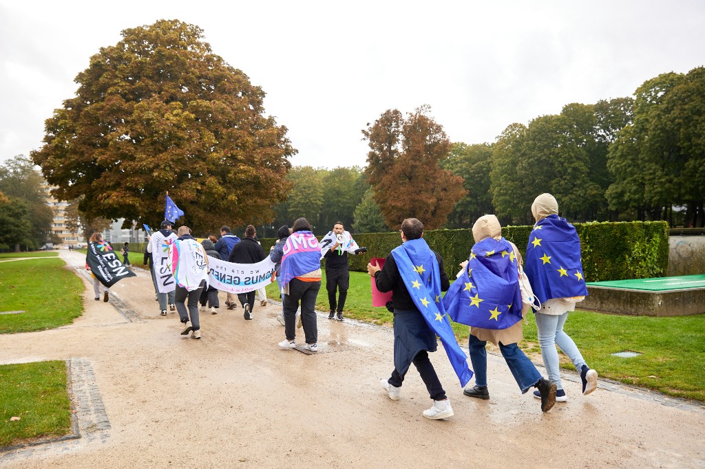 Erasmus participants walking together in a park with EU flags